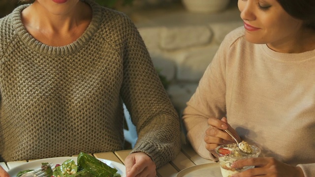 女人吃沙拉，她的朋友享受甜食，健康vs垃圾食品视频素材