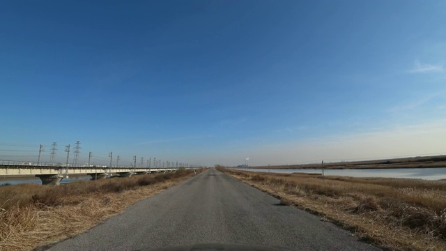 沿河行驶在乡村公路和铁路桥上视频素材