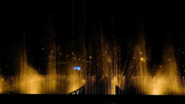 慢动作舞蹈喷泉和喷泉的水在夜晚-灯光，颜色和音乐夜表演视频素材