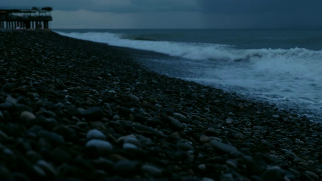 海面上的暴风雨中，海浪拍打着卵石，映衬着雨云视频素材