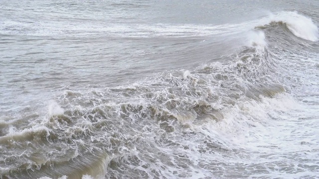 海上风暴。巨浪拍打着海岸，溅起水花。慢动作视频素材