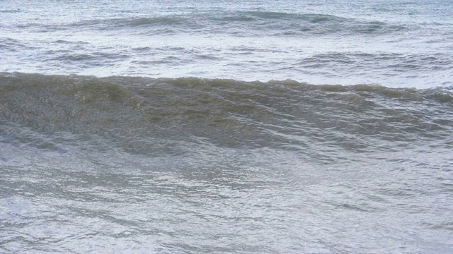 海上风暴。巨浪拍打着海岸，溅起水花。慢动作视频素材