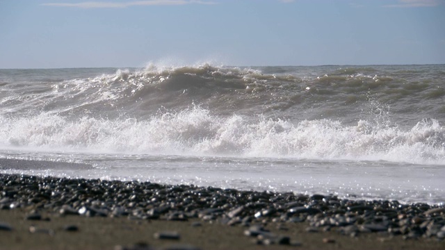 海上风暴。巨浪拍打着海岸，溅起水花。慢动作视频素材