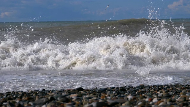 海上风暴。巨浪拍打着海岸，溅起水花。慢动作视频素材