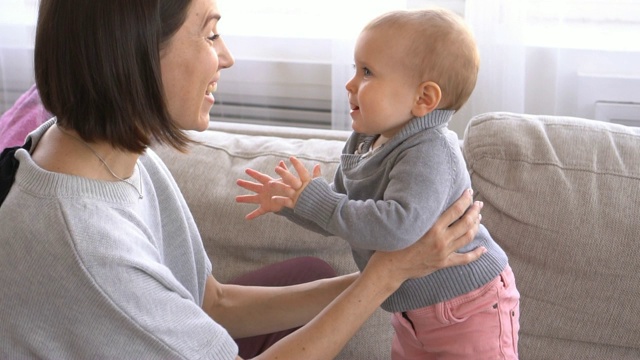 妈妈和她的宝贝女儿在家里拍手视频素材