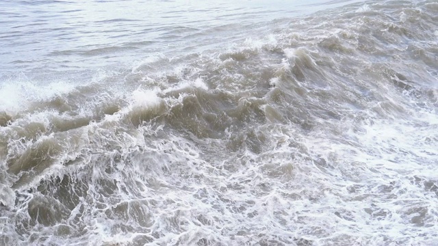 海上风暴。巨浪拍打着海岸，溅起水花。慢动作视频素材