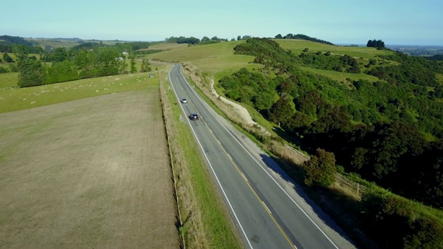 鸟瞰新西兰南岛的乡村道路和绿地，在夏天的山景。视频素材