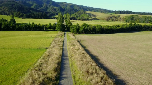 鸟瞰新西兰南岛的乡村道路和绿地，在夏天的山景。视频素材