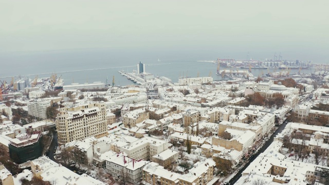 无人机低空飞过敖德萨老城区的冬季海港。城市被雪覆盖视频素材