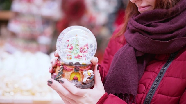 一位年轻漂亮的女士在店里走来走去，挑选圣诞装饰品和装饰品来庆祝新年和圣诞节。视频素材