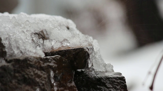 融化的雪在天然石头上。瀑布,冰,水。你好,春天。有选择性的重点。视频素材