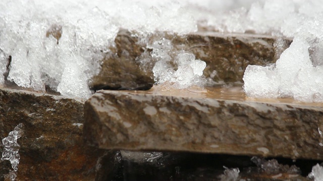 融化的雪在天然石头上。瀑布,冰,水。你好,春天。有选择性的重点。视频素材