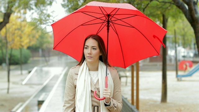 在公园里冒雨散步的严肃女人视频素材