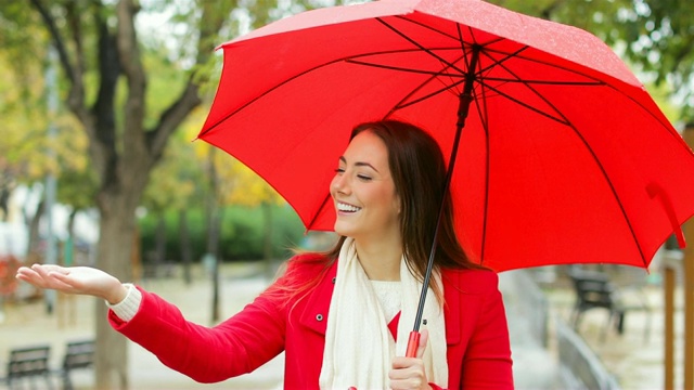 穿着红色的快乐女人在雨中行走视频素材