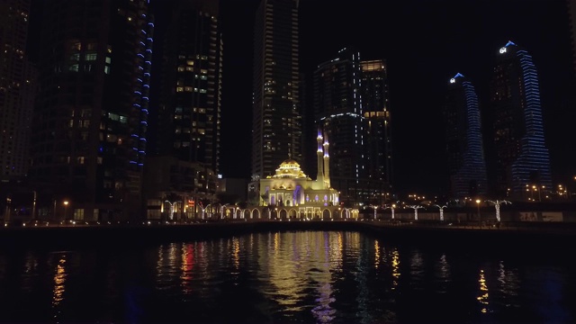 迪拜码头美丽的小清真寺夜景，从漂浮的游船上看视频素材