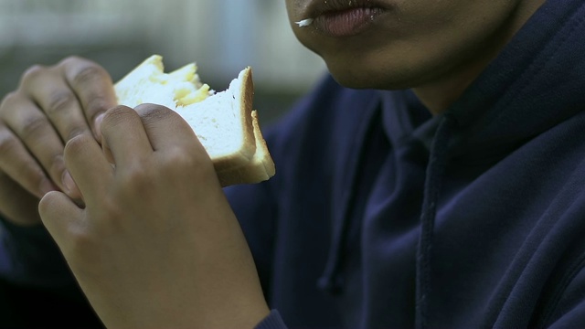 孤独少年在学校食堂吃三明治，局外人，种族问题视频素材