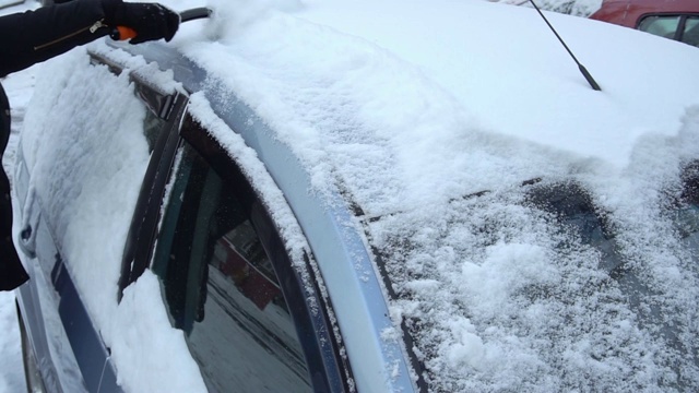 清理车上的积雪。慢镜头清楚视频素材