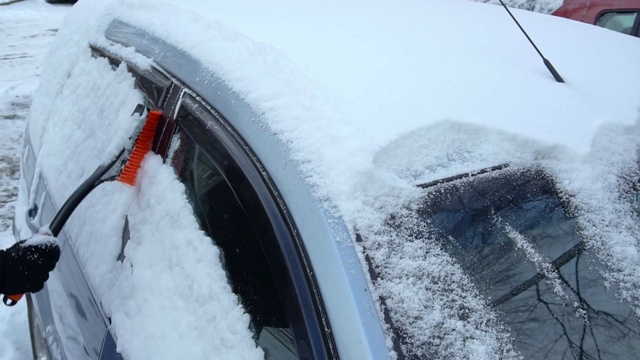 清理车上的积雪。慢镜头清楚视频素材