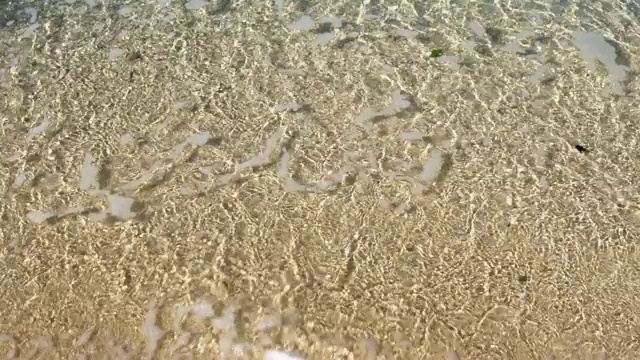 海面上透明的海浪上的沙滩特写视频素材