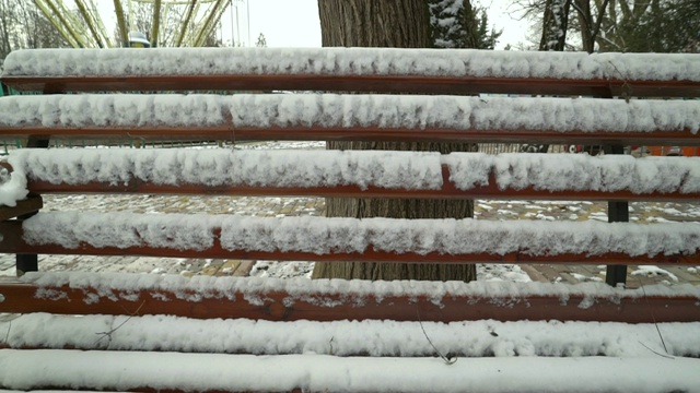 公园里的木凳在冬天被雪覆盖视频素材