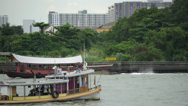 传统的泰国长尾船沿河行驶，河网有轨电车和出租车视频素材