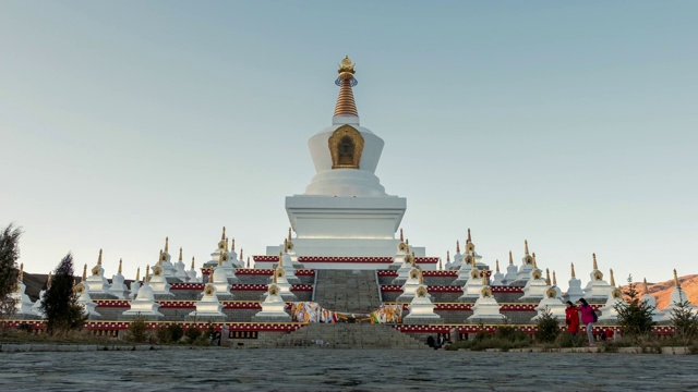 游客步行到白塔的神圣地标稻城，中国视频素材