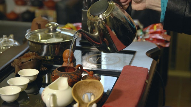 茶道。茶工把开水倒进茶壶里视频素材