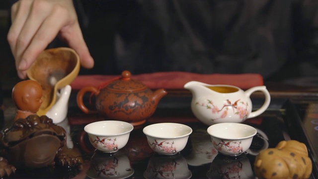 茶道。师傅将茶倒在白色杯子上视频素材