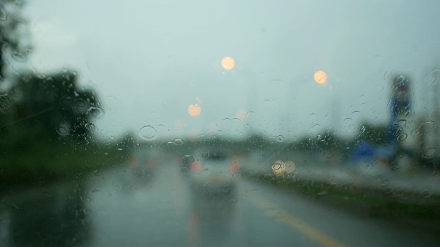 在雨中行驶，背景模糊，灯光散焦的傍晚视频素材