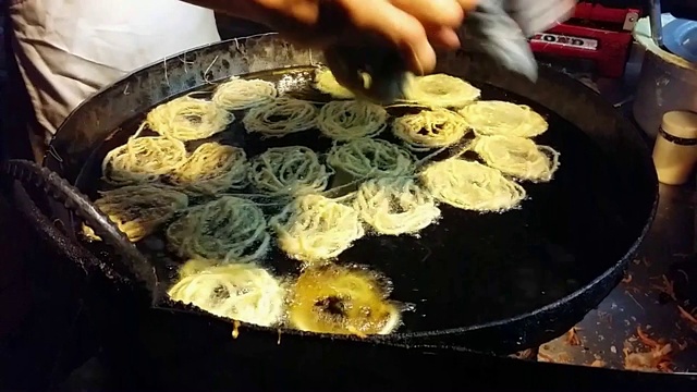 Jalebi(装满糖浆的缠结食物管)是用油烹饪的视频素材