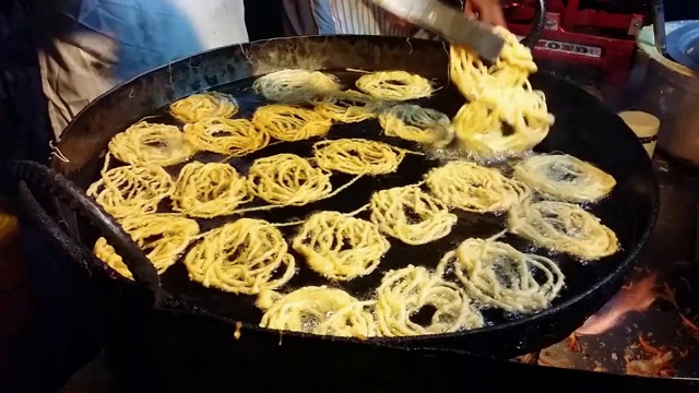 Jalebi(装满糖浆的缠结食物管)是用油烹饪的视频素材