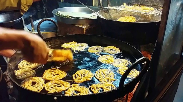 Jalebi(装满糖浆的缠结食物管)是用油烹饪的视频素材