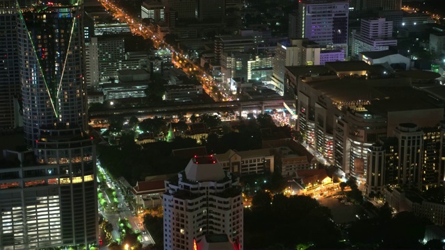 空中夜景照亮城市景观，滚动的城市街道现代建筑视频素材