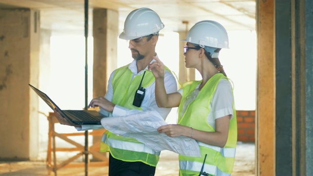 建筑师在建筑工地行走，稳定器拍摄。视频素材