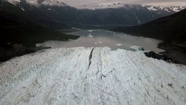 无人机:在黑暗的山脉和云之间的声音俯瞰冰川视频素材