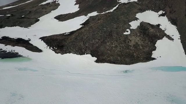 无人机:一个斑驳的雪山和大冰湖的脚视频素材