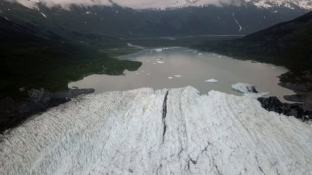 无人机:巨大的白色冰川导致黑暗山脉之间的声音视频素材