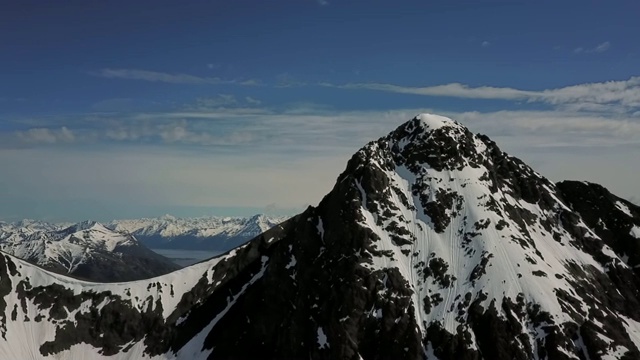 无人机:阳光明媚的雪峰山脉视频素材