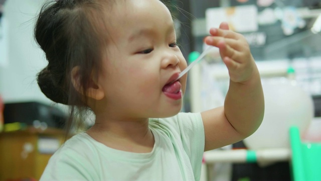 亚洲女婴在家吃牛奶。视频素材