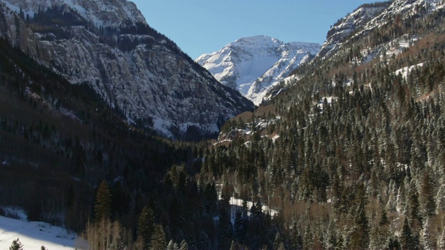 卡车运回无人机拍摄的一个雪谷和圣胡安山(落基山脉)雪峰在乌雷，科罗拉多州晴朗的天空下视频素材