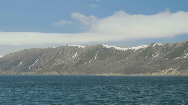 时光流逝，帆船漂浮在碧海和雪峰景观山视频素材