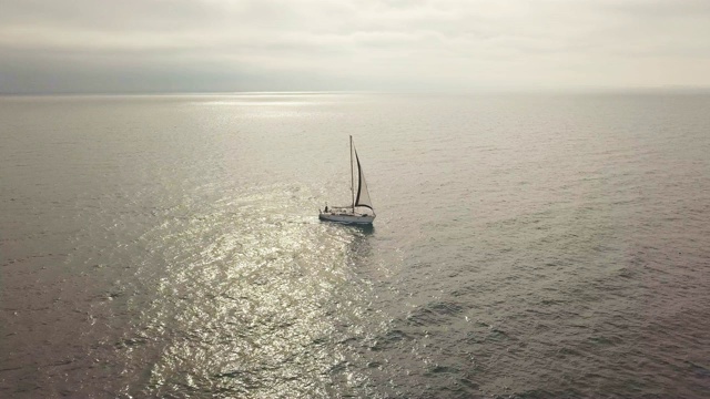 游艇在金色的海面上漂浮，黄昏时分在天空的空中景观视频素材