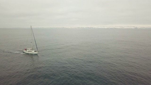 海上漂浮的帆船对雪山景观鸟瞰图视频素材