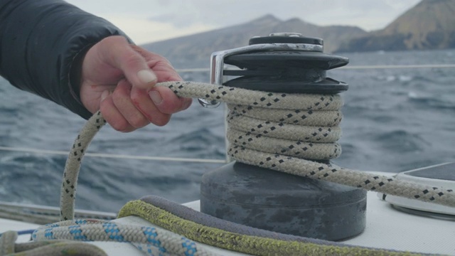 男帆船手拉近帆船上拉绳的距离视频素材