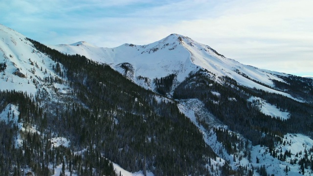 卡车运回无人机拍摄的雪山山峰圣胡安山(洛基山脉附近的红山关口)，在Ouray，科罗拉多州外的冬天被森林包围视频素材