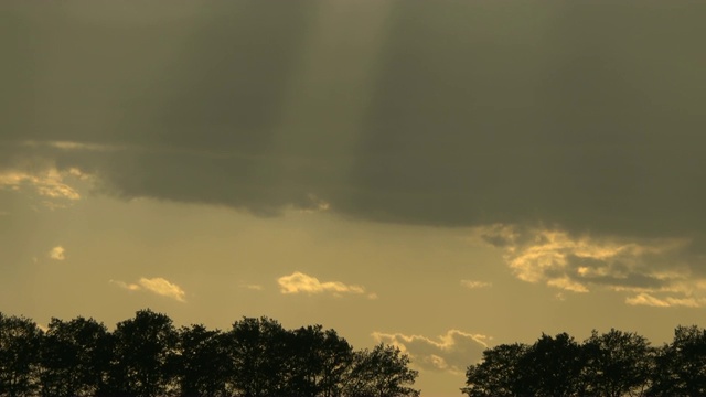 天空中有雨云，日落时有阳光。视频素材