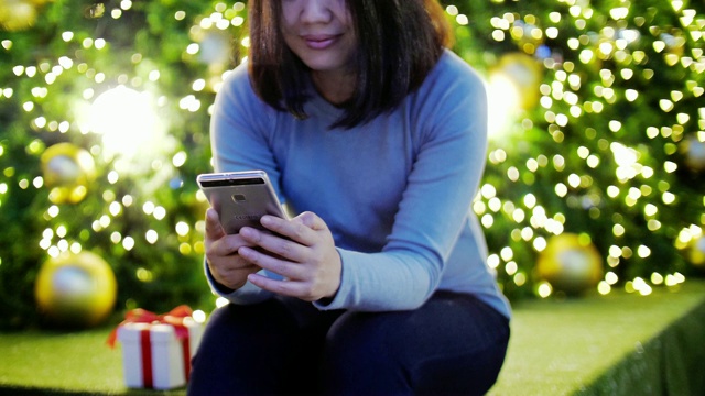 女人用手机与礼盒庆祝圣诞和新年，慢镜头视频素材