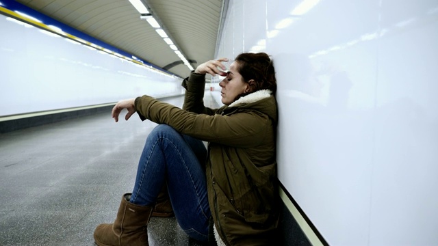 绝望和疲惫的女人在地铁隧道中遭受抑郁和焦虑，工作和生活的平衡问题负面的身体形象，经济问题和紧张的生活事件心理健康和亲人的厕所。视频素材