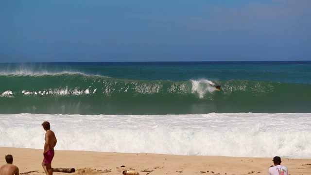 观众在海滩和Bodyboarder捕捉波在慢动作的背景视频素材