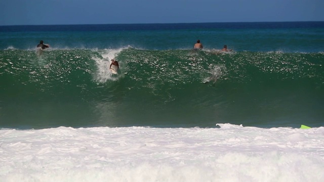 慢动作许多冲浪者和Bodyboarders在水和一个捉浪视频素材